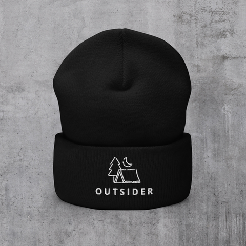 Black knit beanie with embroidered "Outsider" graphic of tent, tree, and moon