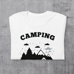 Folded White t-shirt with "Camping: It's like practice for the apocalypse" and graphic of tent, mountains, and evergreen trees.